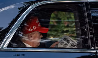 Tổng thống Donald Trump đọc báo khi trên đường đến Câu lạc bộ Golf quốc gia Trump ngày 5/4. (Ảnh: AP)