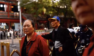 Một phụ nữ ở Bắc Kinh dán hình quốc kỳ lên má. (Ảnh: Reuters)