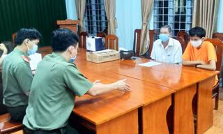 P.T (áo cam) tại cơ quan công an. Ảnh: CACC