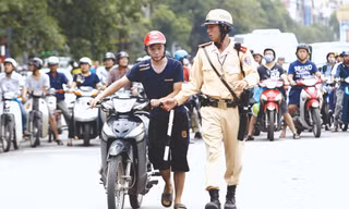 Ngay cả CSGT cũng khó phân biệt mũ giả - mũ thật (ảnh chụp chiều 1/7 tại Hà Nội). Ảnh: Như Ý