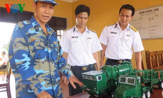 Trung úy chuyên nghiệp Hoàng Văn Tuấn, đội Hỏa lực, Lữ đoàn 679 đang giới thiệu về mô hình xe nạp đạn, xe bệ phóng tên lửa 