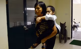 Bố mẹ cõng con gái xương thủy tinh vào tận phòng thi