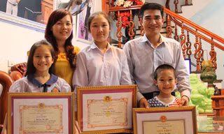 Gia đình anh Thành, chị Yến với những tấm giấy khen của Công an tỉnh Bắc Giang.