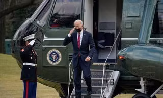Tổng thống Joe Biden giơ tay chào khi ông rời trực thăng chuyên cơ Marine One trên bãi cỏ phía nam của Nhà Trắng.