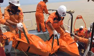 Lực lượng cứu hộ đưa thi thể một thuyền viên lên bờ.