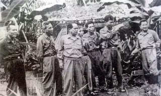 Phó tư lệnh - Tham mưu trưởng Quân giải phóng miền Nam Lê Đức Anh (người đang dơ tay chỉ) và Phó Chính ủy miền Nam Lê Văn Tưởng (ngoài cùng bên trái) cùng các đồng chí trong Bộ Tư lệnh miền Nam tại căn cứ Tà Thiết năm 1971.