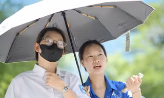 Sinh viên ĐH Thương mại đội nắng hỗ trợ thí sinh làm thủ tục thi tại điểm thi THCS Yên Hòa