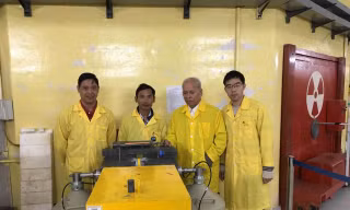 GS Phạm Duy Hiển (thứ hai từ phải) với các nhà khoa học trẻ trước cửa kênh dẫn nơtron lò phản ứng Đà Lạt.