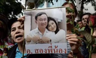 Người ủng hộ cầm ảnh ông Thaksin và em gái Yingluck tại Bangkok hồi tháng 8/2017. Ảnh: AFP.
