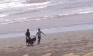 Người dân ven biển Hải Hoà phát hiện và đưa thi thể vào bờ - Ảnh: MĐ