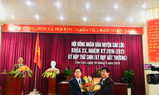 Ông Nguyễn Duy Anh (bìa trái) nhận hoa chúc mừng của lãnh đạo Huyện ủy Cao Lộc .Ảnh: Duy Chiến