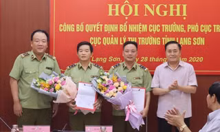 Tân cục trưởng, phó cục trưởng QLTT Lạng Sơn (giữa) nhận quyết định, hoa của lãnh đạo Tổng cục QLTT và lãnh đạo tỉnh Lạng Sơn. Ảnh: Duy Chiến
