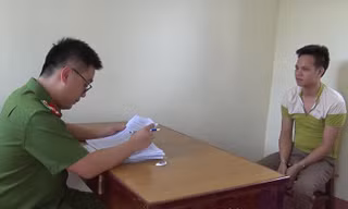 Đối tượng Hoàn (bìa phải) tại cơ quan công an .Ảnh: Minh Anh