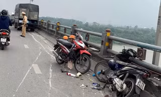 Xe tải lao vào dải phân cách cầu Thanh Trì, hai người đi xe máy gặp họa
