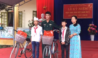 Chỉ huy Tiểu đoàn Huấn luyện - Cơ động Bộ đội Biên phòng Lào Cai tặng xe đạp cho hai em Thắng và Vảng