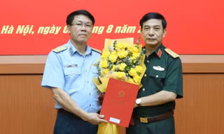 Thừa ủy quyền của Chủ tịch nước Nguyễn Xuân Phúc, Đại tướng Phan Văn Giang, Phó Bí thư Quân ủy Trung ương, Bộ trưởng Bộ Quốc phòng trao quyết định thăng quân hàm từ Thiếu tướng lên Trung tướng cho Quyền Tư lệnh Vũ Văn Kha (bên trái ảnh).
