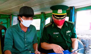 Cán bộ Đồn Biên phòng Cần Thạnh (TPHCM) hướng dẫn người dân các biện pháp phòng chống dịch COVID-19