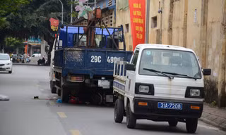 Hiện trường vụ tai nạn, chiếc xe máy của nạn nhân nằm trong gầm chiếc xe tải chạy lùi (màu xanh)