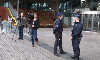 Cảnh sát và nhà báo bên ngoài Tòa án Antwerp, Bỉ