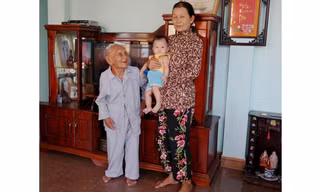 Cụ Một bên cạnh con dâu và chắt nội. Cụ có hơn 40 cháu, chắt. Ảnh: Đoàn Nguyên.