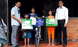 Đại diện báo Tiền Phong và Công ty Điện lực tỉnh Vĩnh Long trao quà cho em Lý Lam Chiều và em trai Lý Gia Trường.