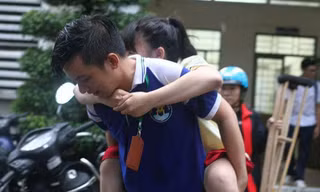 Xúc động, tình nguyện viên cõng nữ sinh gãy chân leo cầu thang
