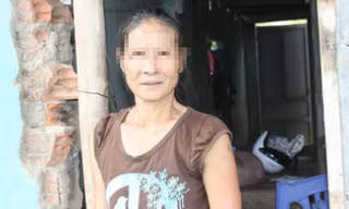 Chị Nguyệt trong căn nhà tường gạch loang lổ.