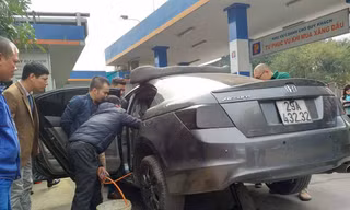 Nhân viên cây xăng rút xăng từ chiếc xe Honda Accord ra thùng. Ảnh: M.Đ