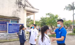 Học sinh được đo thân nhiệt trước khi vào lớp học.