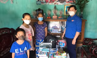 Chị Lê Thị Thanh Bắc (Bí thư Đoàn TNCS Hồ Chí Minh xã Đồng Lạc) thay mặt Nhà sách Tiền Phong tặng quà cho hai em Dương và Duy.