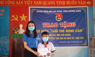Thừa uỷ quyền của BCH Trung ương Đoàn TNCS Hồ Chí Minh, đại diện Tỉnh đoàn Quảng Bình trao huy hiệu "Tuổi trẻ dũng cảm" cho học sinh Mai Hải Đăng.