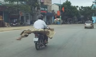 Không tiền, anh Lò Văn Muôn buộc phải chở thi thể em gái về nhà bằng xe máy.