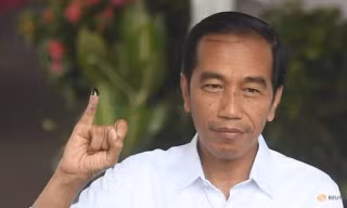 Tổng thống Indonesia Joko Widodo giơ ngón tay in mực sau khi bỏ phiếu tại thủ đô Jakarta