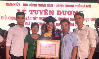 Phạm Thị Nhung bên gia đình tại lễ tuyên dương thủ khoa đầu ra xuất sắc vừa qua.