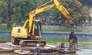 Nạo hút bùn bằng máy xúc ở hồ Hoàn Kiếm Ảnh: M.H