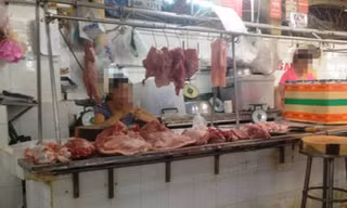 Gần hết ngày nhưng bàn vẫn còn đầy thịt heo, tiểu thương chơi điện thoại “giết” thời gian 
