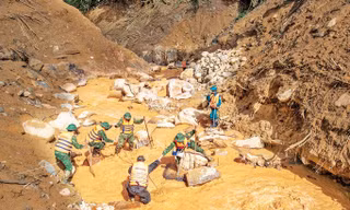 Dìu nhau vượt suối Ảnh: Lê Văn Chương 