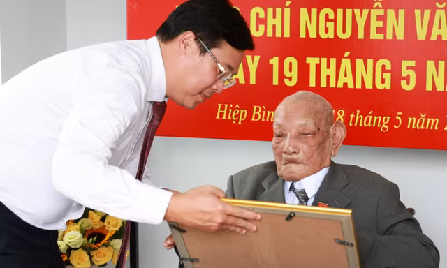 Ông Lê Quốc Phong trao Huy hiệu 80 năm tuổi Đảng tới hai cán bộ