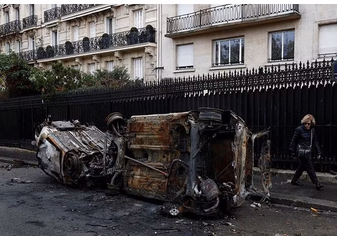 Một chiếc xe hơi bị đốt cháy trên đường phố Paris ngày 1/12 Ảnh: Getty Images