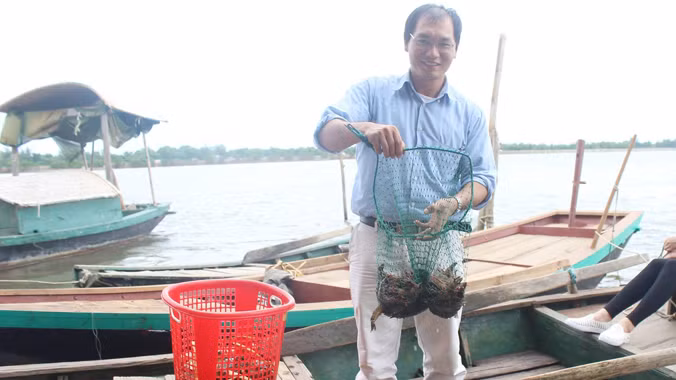 Anh Nguyễn Văn Nguyên bên trang trại nuôi tôm sú, cua biển của gia đình. Ảnh: Quang Lộc.