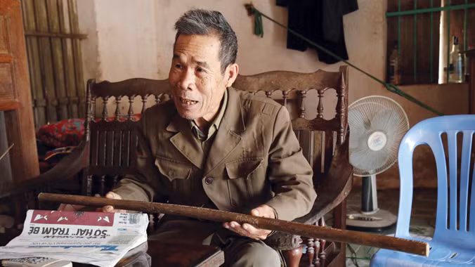 Ông Quán bồi hồi kể lại những kỷ niệm cùng chiếc gậy Trường Sơn. Ảnh: Dương Lê.
