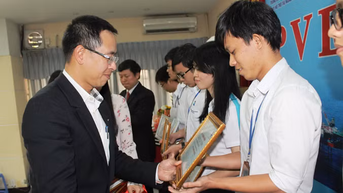 Ông Trần Bình Minh trao học bổng cho sinh viên.