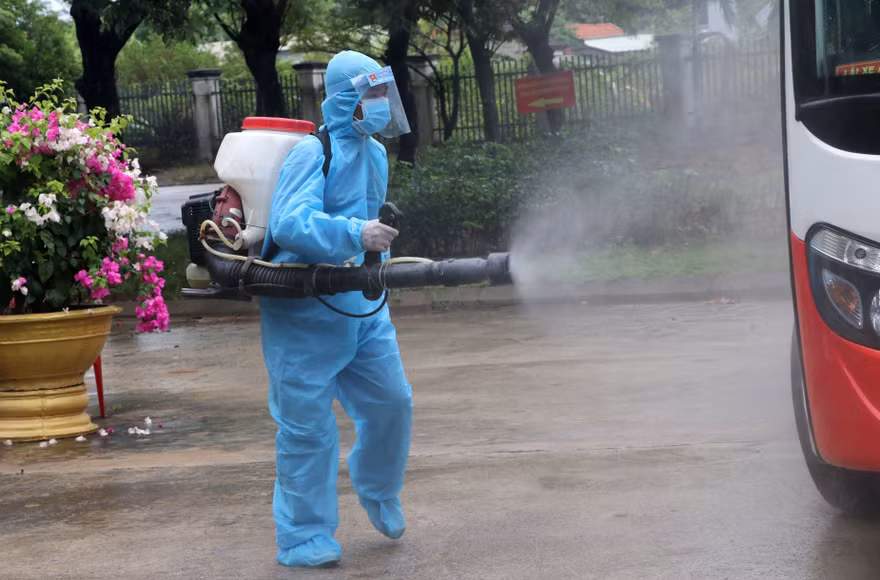 Nhân viên y tế khử trùng các phương tiện ra vào khu vực bệnh viện dã chiến Hòa Vang (Đà Nẵng). Ảnh TTXVN