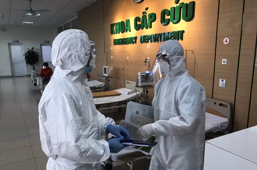Điều dưỡng Trường (phải) đang trao đổi với đồng nghiệp về bệnh nhân nghi nhiễm