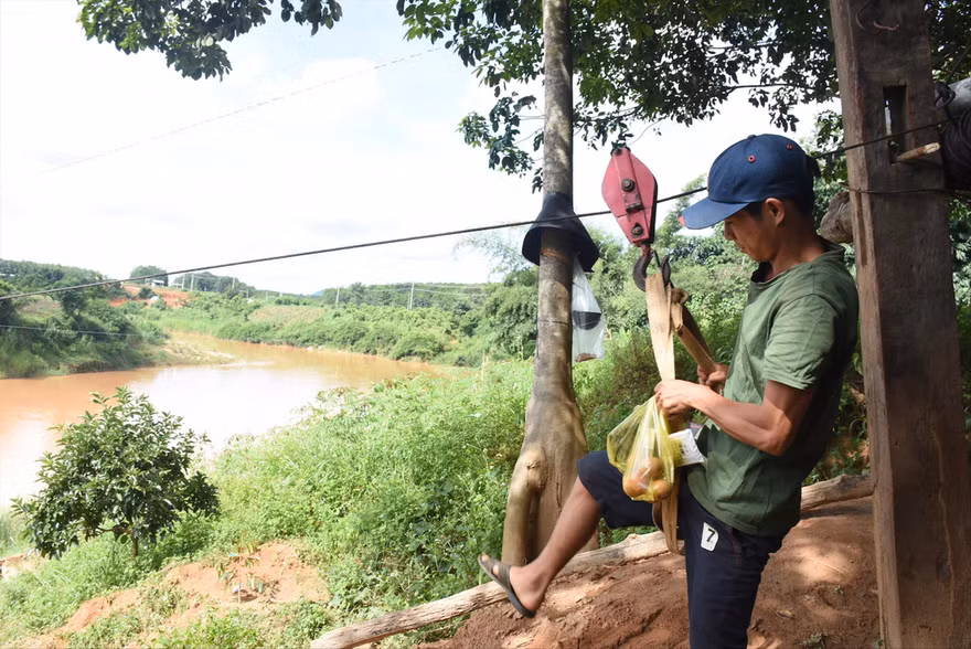 Người dân liều mình đu qua sông trên sợi dây cáp 
