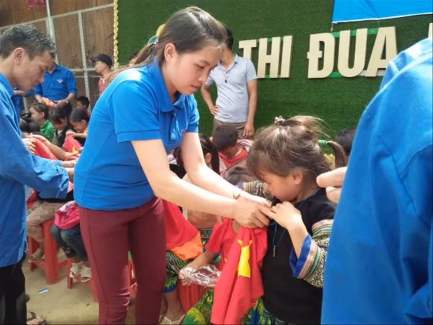 Bí thư Đoàn xã Lao Chải Lý Thị Thiêm tặng quà cho trẻ em dân tộc thiểu số Ảnh: CTV 
