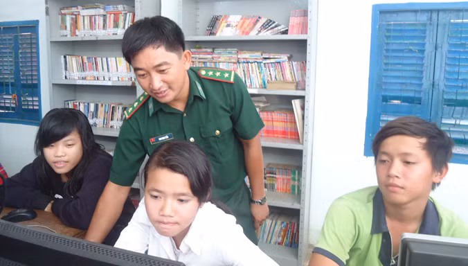 Cán bộ Trạm biên phòng Thiềng Liềng (thuộc Đồn biên phòng Thạnh An) đang hướng dẫn các em học sinh làm quen với máy vi tính.
