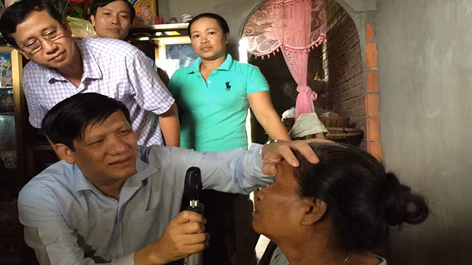 Thứ trưởng Nguyễn Thanh Long kiểm tra mắt cho bệnh nhân Lý Thị Hiên. Ảnh: L.N.