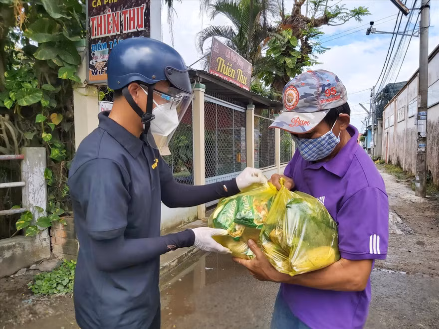 Tình nguyện viên trao quà cho ông Nguyễn Văn Phúc