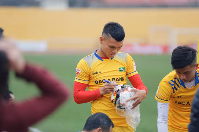 Phạm Xuân Mạnh và Phan Văn Đức ký tên vào quả bóng lưu niệm dành cho người hâm mộ tại buổi tập. Ảnh: Hồng Vĩnh.